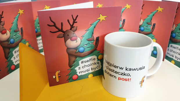 Kartka bożonarodzeniowa z choinką i reniferem oraz kubek social mediaz napisem z napisem: "Najpierw kawusia i ciasteczko, potem post!"